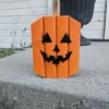 Small Orange Jack-O-Lantern made from 2x4 and a natural branch as stem.