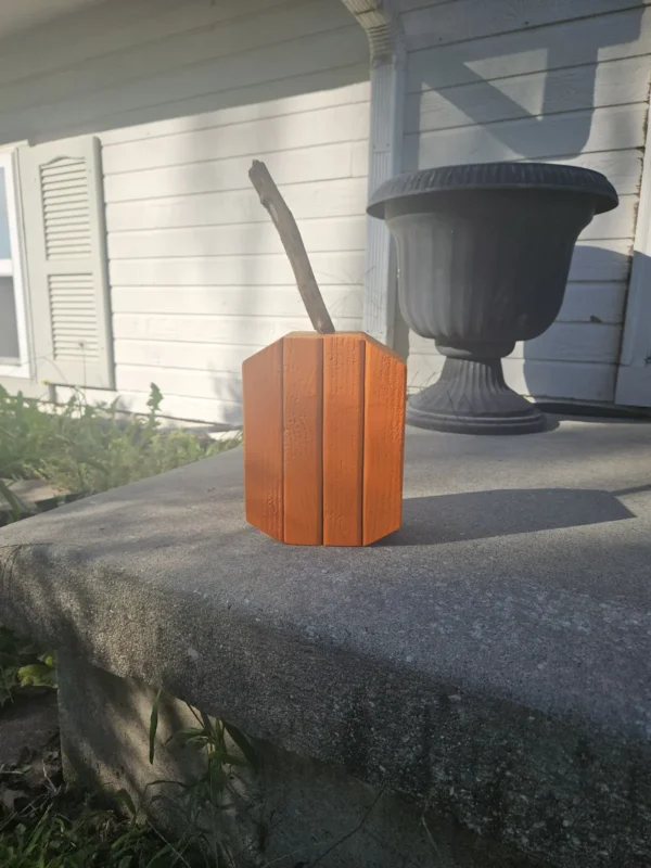 Small Orange Jack-O-Lantern made from 2x4 and a natural branch as stem.
